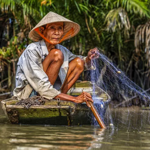Roundtrip-Vietnam-South-Vietnam-Phu-Quoc-Day3-4-5-Can-Tho-man catching fishes-Mekong River Delta-GettyImages-904169758-1.jpg